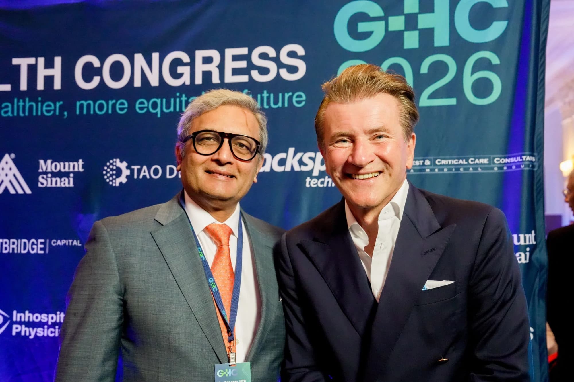 Two attendees at the sponsor wall